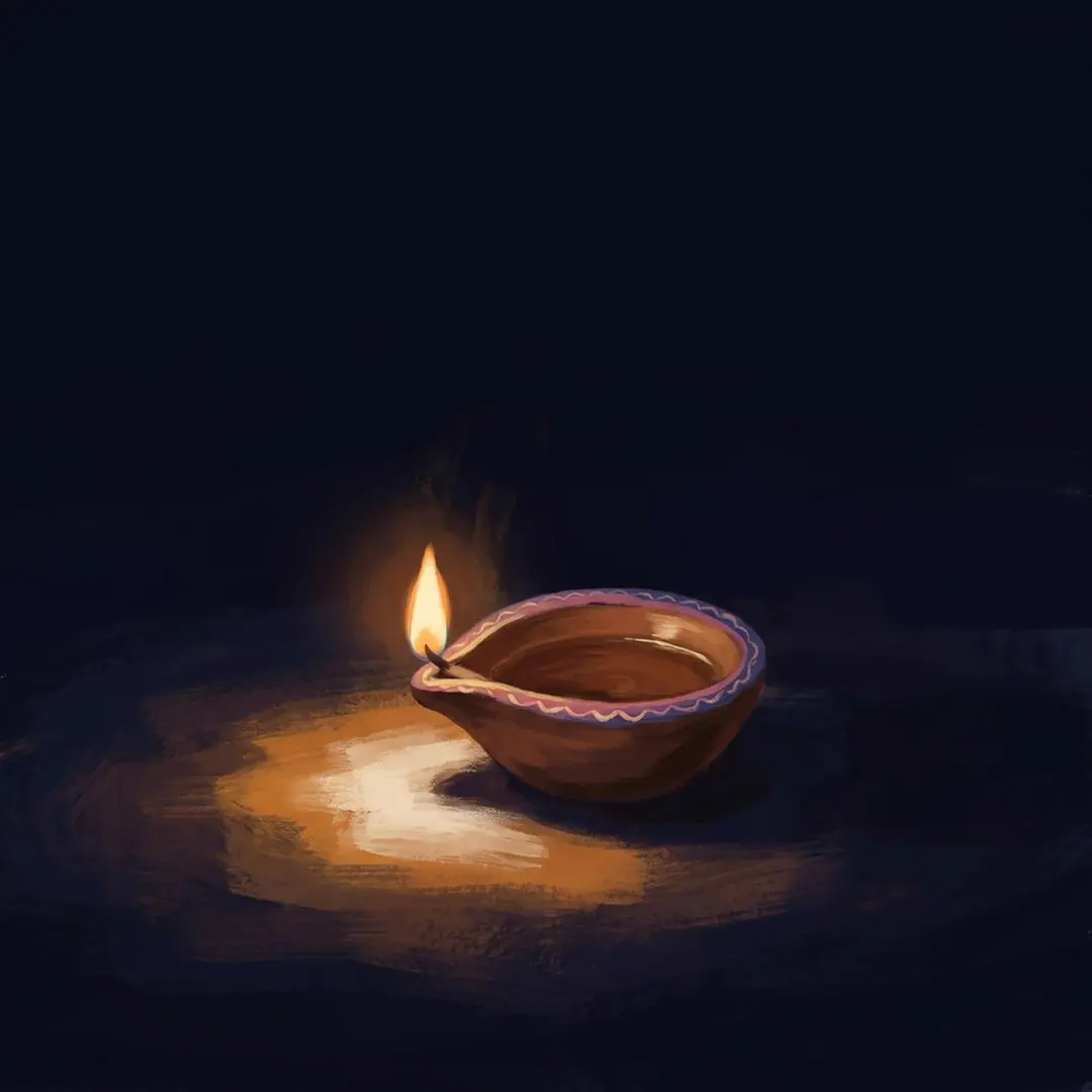 A single lit clay diya in the dark.